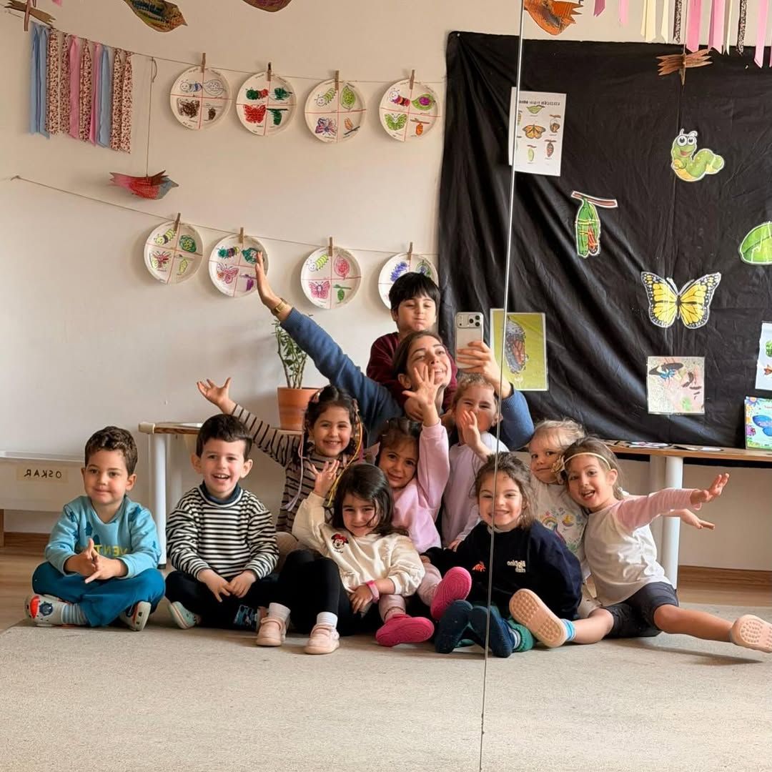 Sınıfta ayna karşısında birlikte poz veren çocuk grubu